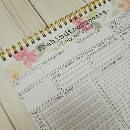 Undated daily productivity planner notepad with floral design, goal setting, and schedule sections.