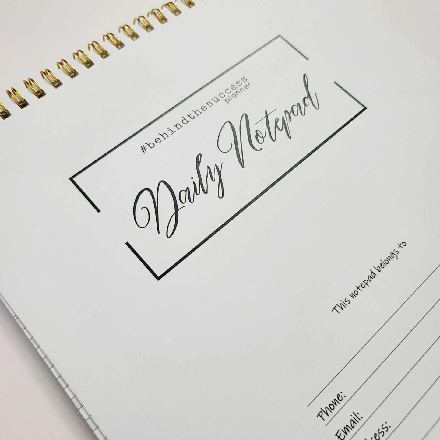 Daily notepad planner with gold spiral binding for productivity and goal tracking