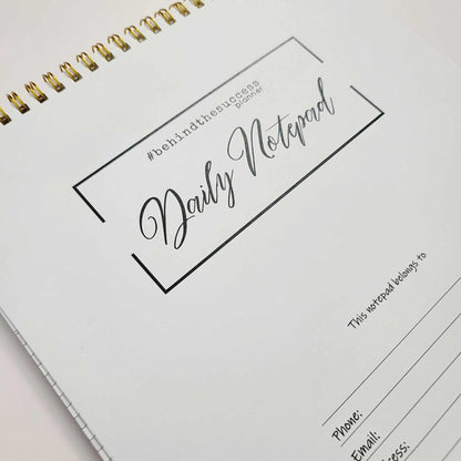 Daily notepad planner with gold spiral binding for productivity and goal tracking