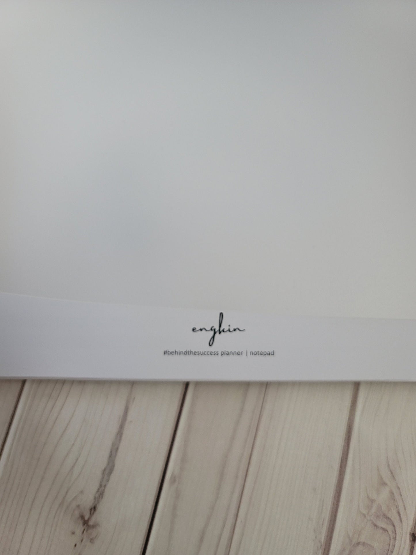 Minimalist blank notepad page on light wood desk, productivity planner stationery