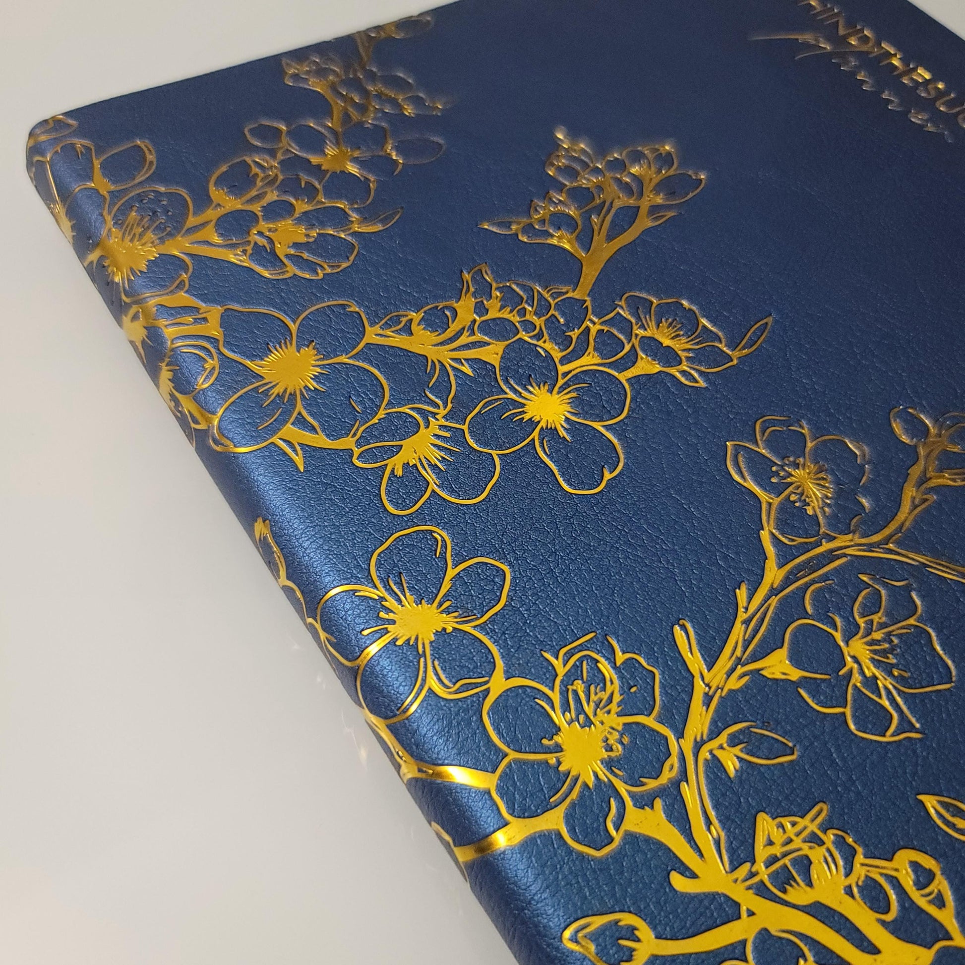 Blue productivity planner with gold floral embossing on textured cover