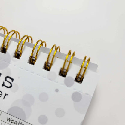 Close-up of gold spiral binding on undated productivity life planner page