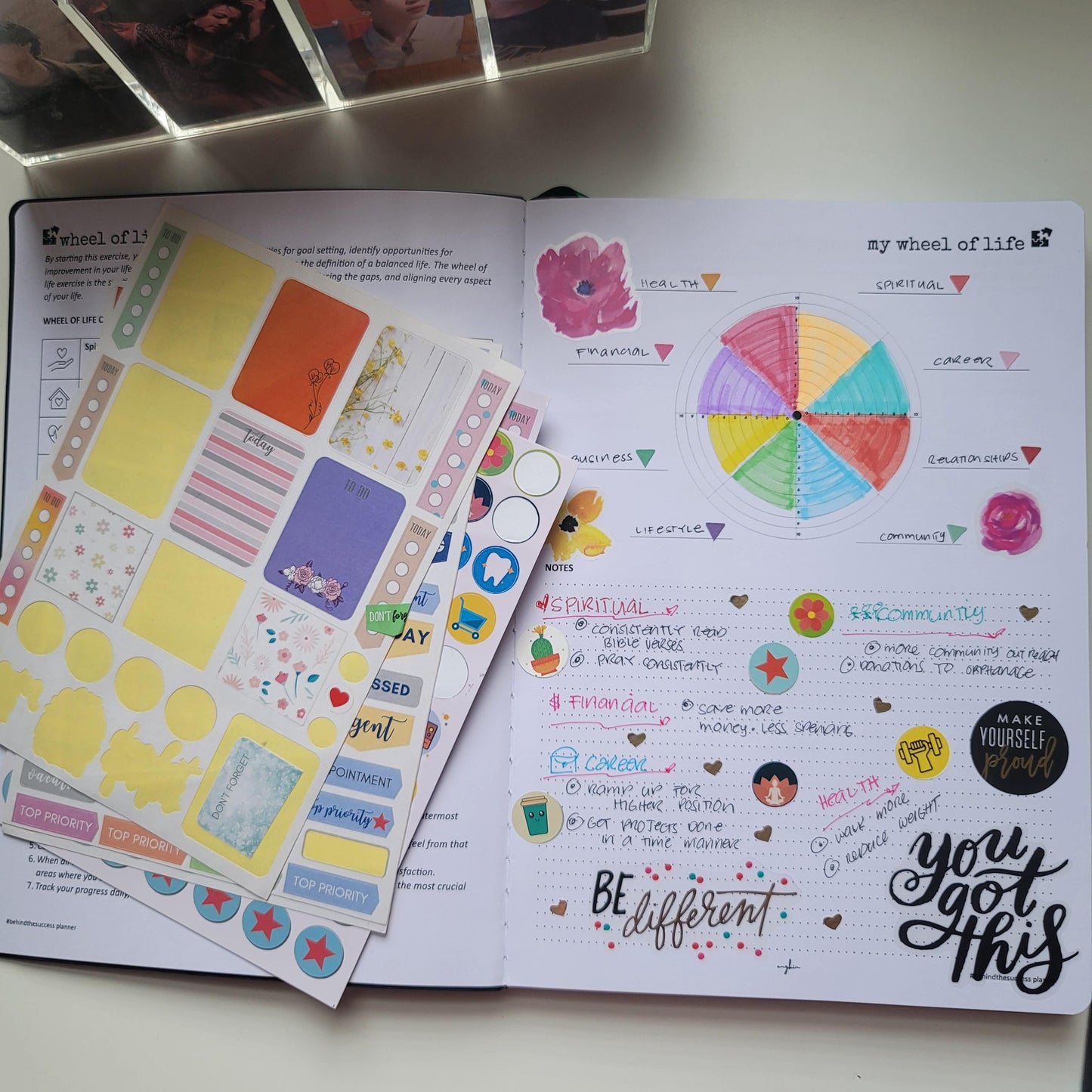 Open life planner with colorful wheel of life chart, handwritten notes, and decorative stickers
