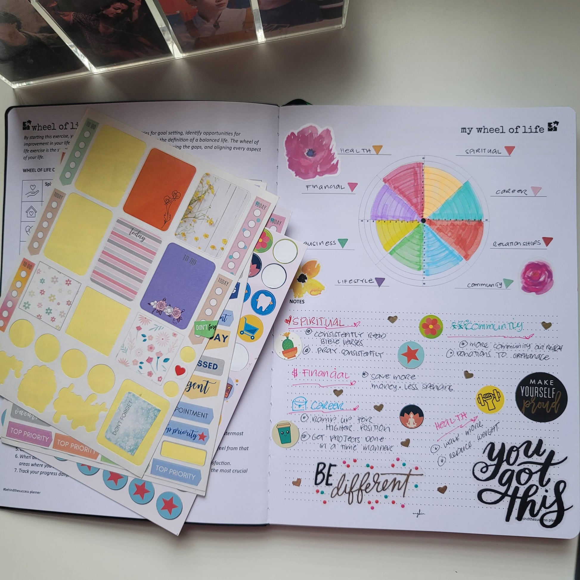 Open life planner with colorful wheel of life chart, handwritten notes, and decorative stickers