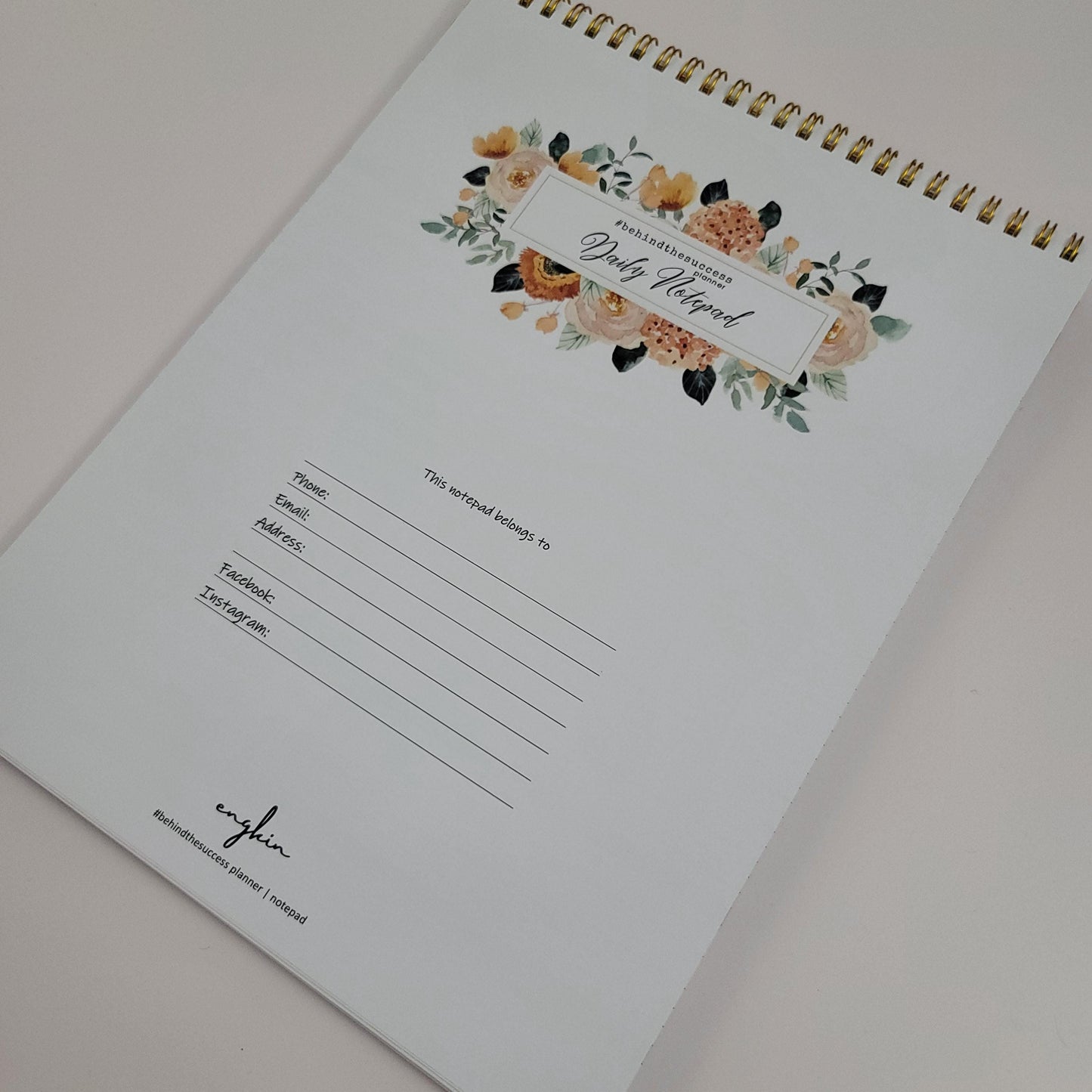 Floral undated productivity planner notepad with gold spiral binding, contact info section.