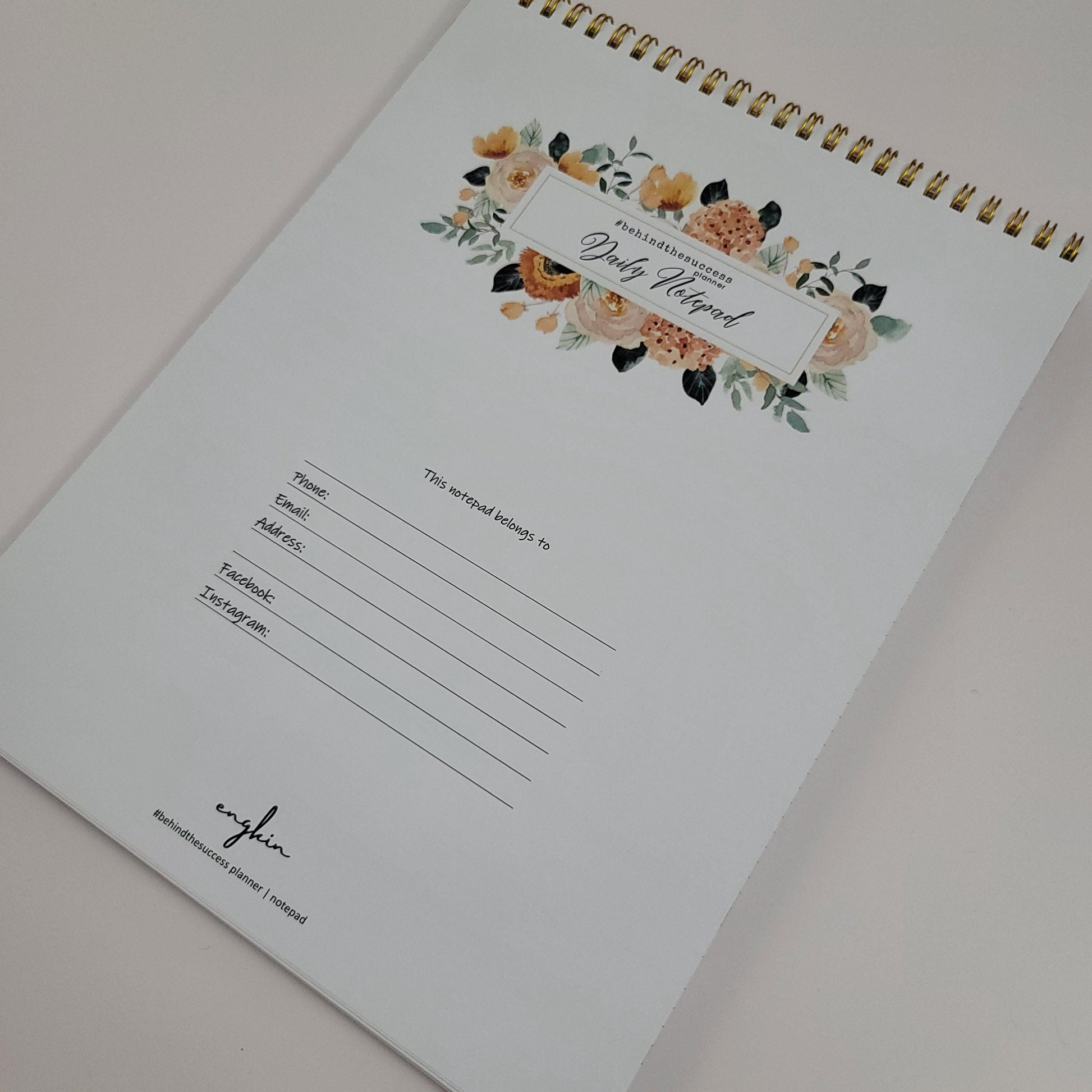 Floral undated productivity planner notepad with gold spiral binding, contact info section.